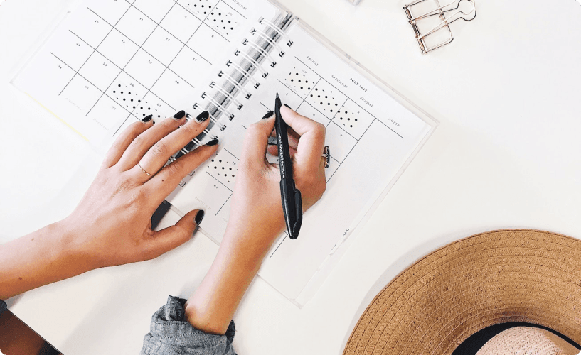 Writing on notebook with hat